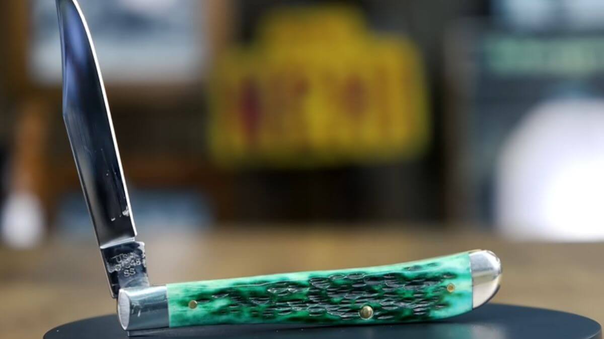 Case knife with green handle, displaying a shiny blade and logo stamp